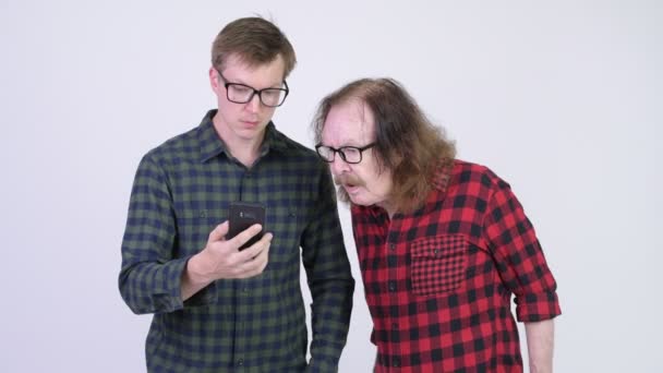 Homme hipster sénior attrapant jeune homme hipster utilisant le téléphone et regardant coupable — Video