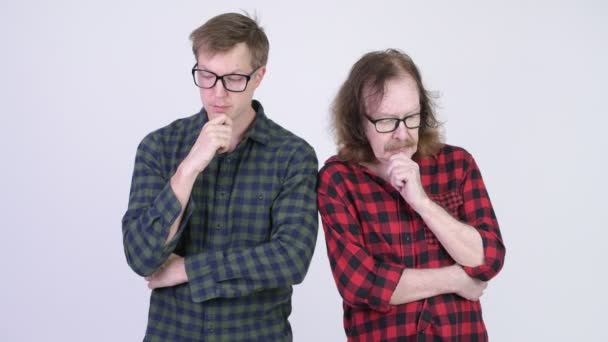 Grave anziano hipster uomo e giovane hipster uomo pensando mentre guardando giù insieme — Video Stock