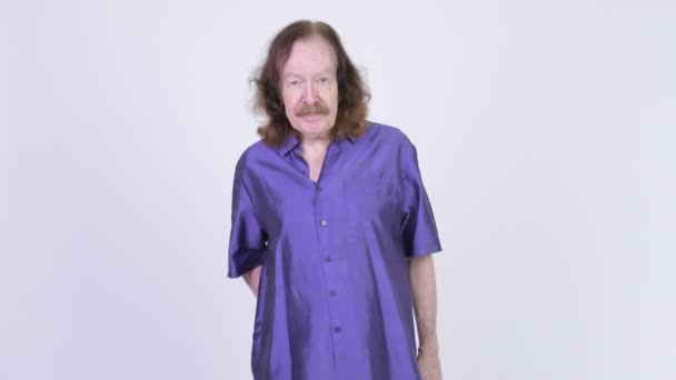 Hombre mayor feliz con camisa sedosa púrpura mostrando caca artificial — Vídeo de stock