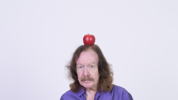 Senior man with apple on head looking shocked — Stock Video