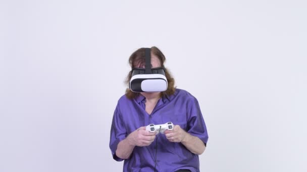 Hombre mayor feliz jugando juegos mientras usa auriculares de realidad virtual — Vídeo de stock