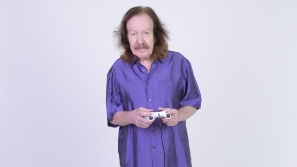 Happy senior man with purple silky shirt playing games and winning — Stock Video