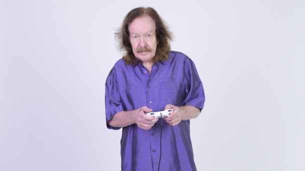 Senior man with purple silky shirt playing games and falling asleep — Stock Video