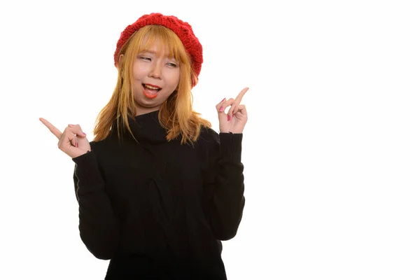 Young happy Asian woman smiling and thinking while pointing both — Stock Photo, Image