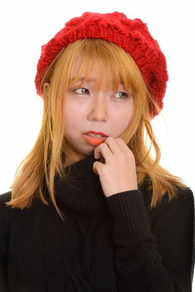 Cara de joven linda mujer asiática pensando mientras sostiene suéter — Foto de Stock