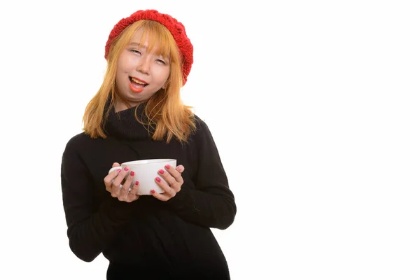 Joven feliz mujer asiática sonriendo y sosteniendo la taza de café —  Fotos de Stock