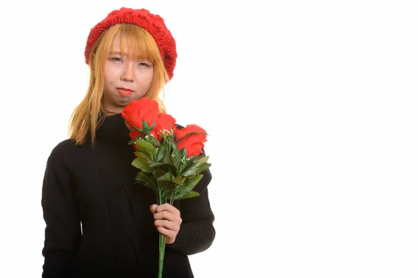 Joven lindo asiático mujer holding rojo rosas buscando molesto —  Fotos de Stock