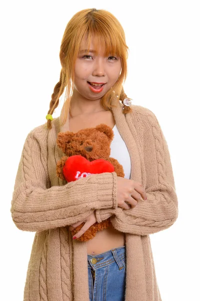 Gelukkig Aziatische jongedame glimlachend en knuffelen teddybeer met horen — Stockfoto