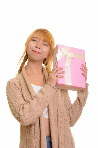 Junge nachdenkliche Asiatin rät Geschenkbox — Stockfoto