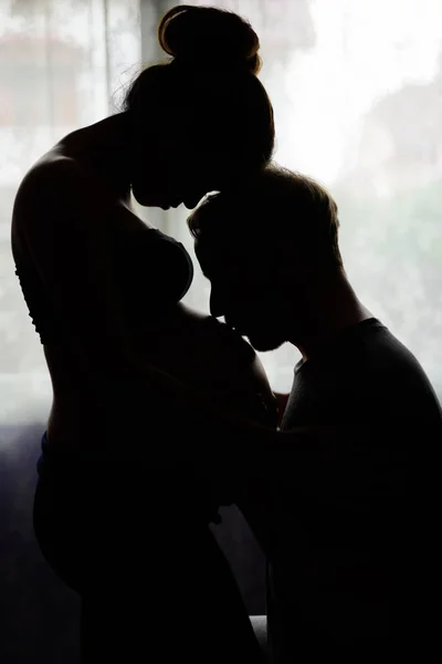 Coppia multietnica sposata e innamorata in silhouette dalla vittoria — Foto Stock