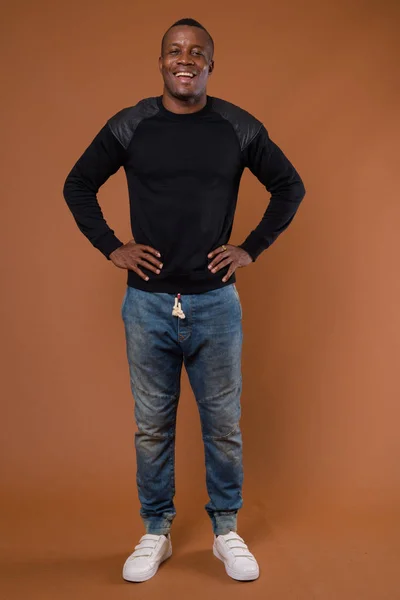 Studio skott av unga afrikanska man mot brun bakgrund — Stockfoto