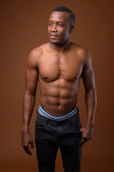 年轻的赤裸上身的非洲男子反对褐色背景 — 图库照片