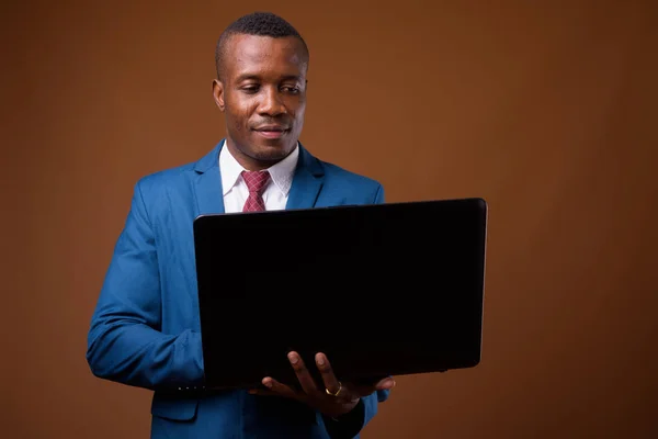 Estúdio tiro de jovem empresário africano contra backgroun marrom — Fotografia de Stock