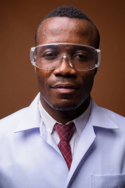 Genç Afrika adam doktor kahverengi arka plan stüdyo çekim