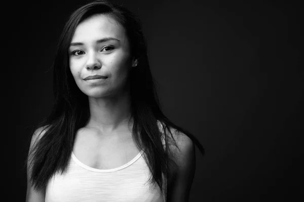 Mujer asiática joven contra fondo gris en blanco y negro — Foto de Stock