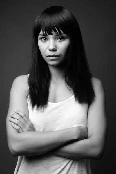 Young Asian woman against gray background in black and white — Stock Photo, Image