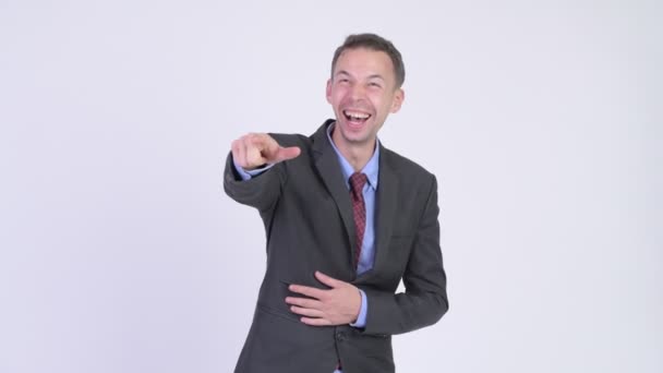 Студійний знімок щасливого бізнесмена сміється і вказує пальцем — стокове відео