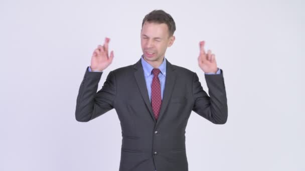 Studio shot of businessman wishing with fingers crossed — Stock Video