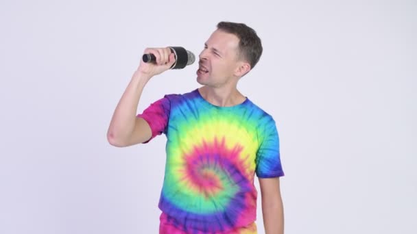 Studio shot of man with tie-dye shirt singing with microphone — Stock Video