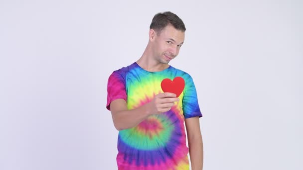 Happy man wearing tie-dye shirt and giving red heart — Stock Video