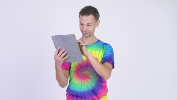 工作室拍摄的快乐男子与领带染料衬衫使用数字平板电脑 — 图库视频影像