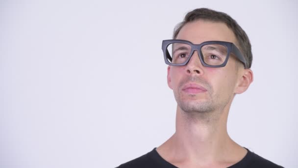 Studio shot of happy nerd man with eyeglasses thinking — Stock Video