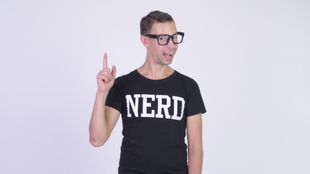 Estudio de tiro de hombre nerd feliz sonriendo y señalando hacia arriba — Vídeo de stock