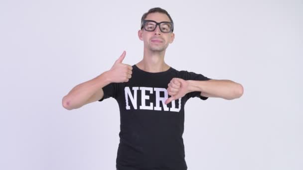 Studio schot van nerd man kiezen tussen duimen omhoog en — Stockvideo