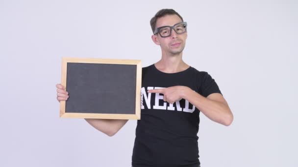 Studio shot of happy nerd man showing blackboard and giving thumbs up — Stock Video