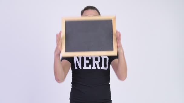 Estudio de tiro de hombre nerd feliz mostrando pizarra como sorpresa — Vídeos de Stock