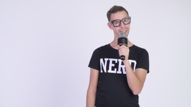 Studio shot van nerd man die iets presenteert met microfoon — Stockvideo