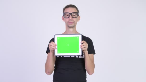 Studio záběr šťastný nerd člověka ukazuje digitální tabletu — Stock video