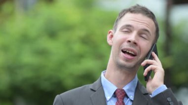 Mutlu işadamı telefon açık havada üzerinde konuşurken düşünme