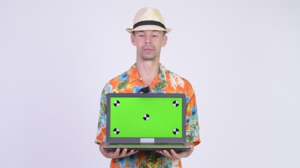 Glad turist man ler medan visar laptop — Stockvideo