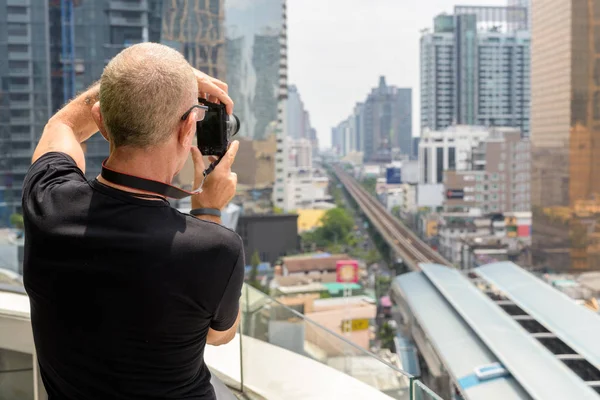 Rückansicht des glatzköpfigen Senior-Touristen, der die Aussicht fotografiert — Stockfoto
