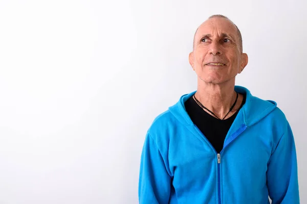 Studio shot of happy bald senior man smiling and thinking agains — Stock Photo, Image