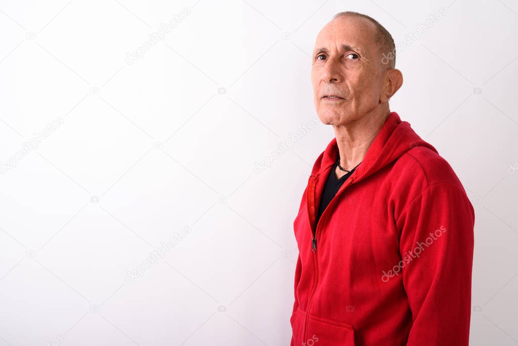 Bald senior man standing against white background