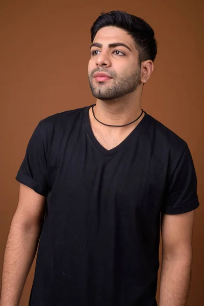 茶色の背景に対して若いハンサムなインド人 — ストック写真