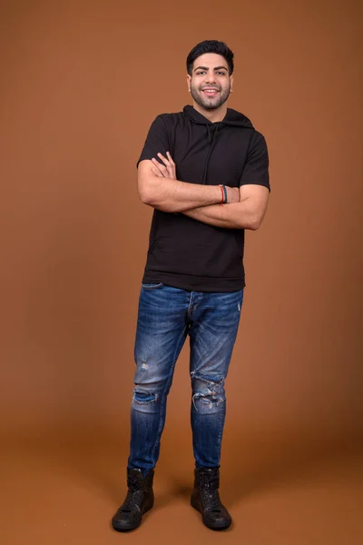 Junger hübscher indischer Mann mit braunem Hintergrund — Stockfoto