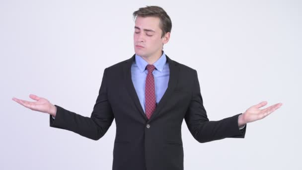 Junger gutaussehender Geschäftsmann vergleicht etwas — Stockvideo
