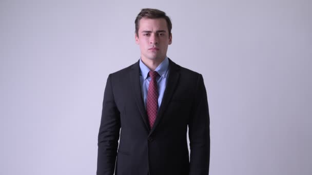 Joven hombre de negocios guapo usando traje con los brazos cruzados — Vídeos de Stock