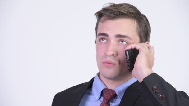 Mladý šťastný pohledný podnikatel myšlení při telefonování — Stock video