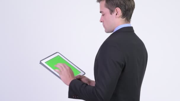Вид сзади на молодого привлекательного бизнесмена с помощью цифрового планшета — стоковое видео