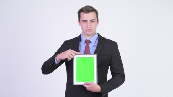 Joven feliz hombre de negocios guapo mostrando tableta digital — Vídeos de Stock