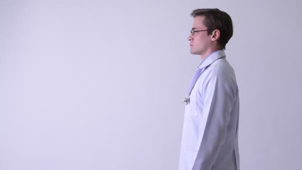 Perfil vista de jovem feliz bonito homem médico sorrindo — Vídeo de Stock