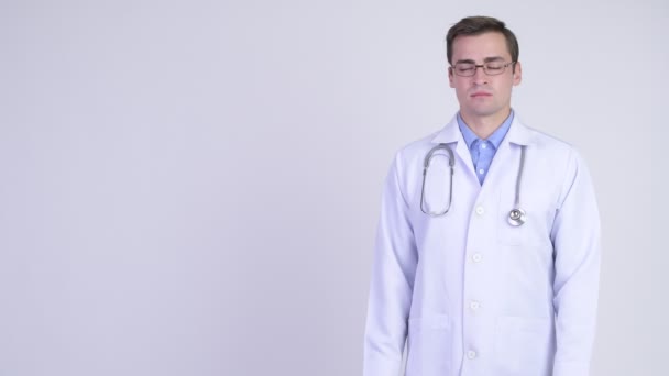 Молодой счастливый красивый мужчина доктор показывает что-то — стоковое видео