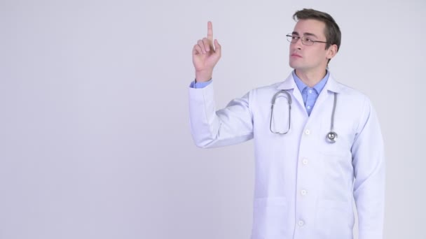 Jeune homme heureux beau médecin penser tout en pointant vers le haut — Video