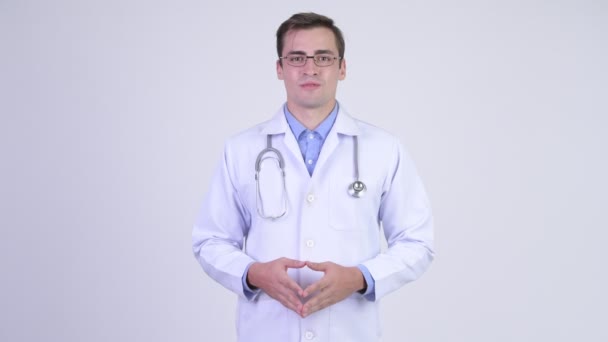 Ευτυχισμένος όμορφος νεαρός γιατρός παρουσιάζει κάτι — Αρχείο Βίντεο
