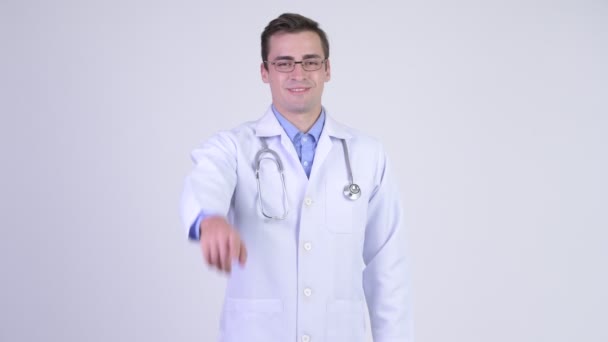 Pohledný mladík happy doktor ukazující na fotoaparát — Stock video