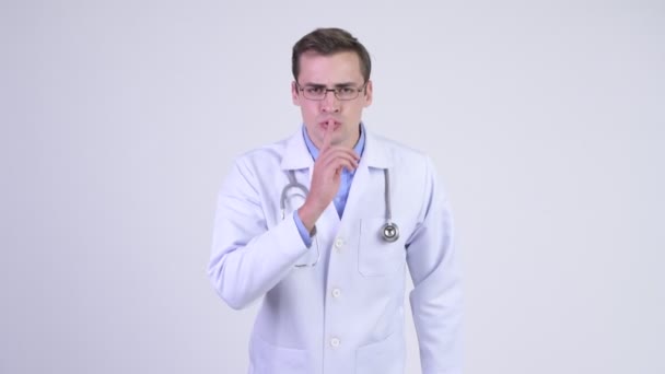 Σοβαρές νεαρός γιατρός με το δάχτυλο στα χείλη — Αρχείο Βίντεο